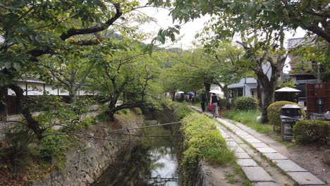 La-Gente-Camina-Con-Sombrillas-En-El-Camino-Del-Filósofo-Kyoto,-Famoso-Destino-Turístico-De-Japón-En-Verano