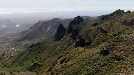 Aerial-view-traveling-in-over-Roque-Chico-and-Roque-Grande-in-the-nature-reserve,-on-the-island-of-Gran-Canaria-on-a-sunny-day