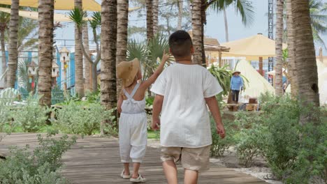Two-little-Asian-kids-walk-around-the-farm-on-the-beach