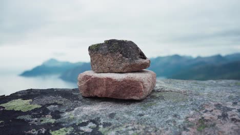 Stacking-rocks-in-Kvaenan-Mountains-in-Norway,-overlooking-landscape