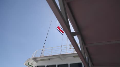 Bandera-De-Costa-Rica-Ondeando-En-El-Aire-En-Un-Ferry-Con-Un-Cielo-Azul-Claro-En-El-Fondo