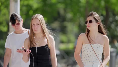 Close-up-telephoto-shot-in-slow-motion-of-teenage-girls-crossing-street