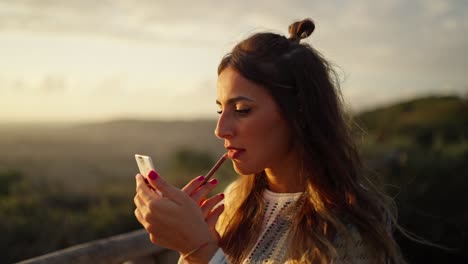 Slow-motion-shot-of-a-model-touching-up-her-makeup-in-between-shoots-during-sunset