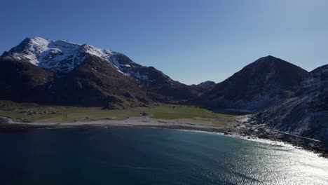 Norwegian-beach-at-Uttakleiv-on-a-sunny-day-during-the-end-of-the-winter-season-in-Lofoten,-Aerial-forwarding-shot