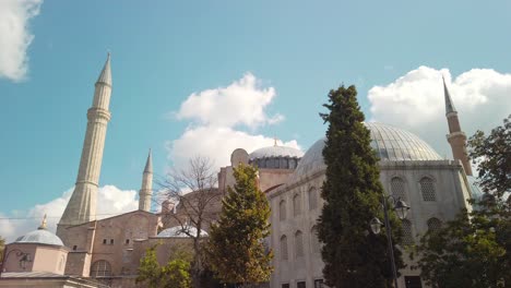 Daytime,-under-partly-cloudy-skies,-cinematic-slow-mo,-Hagia-Sophia-Mosque-with-its-minarets-and-a-few-trees-in-the-foreground