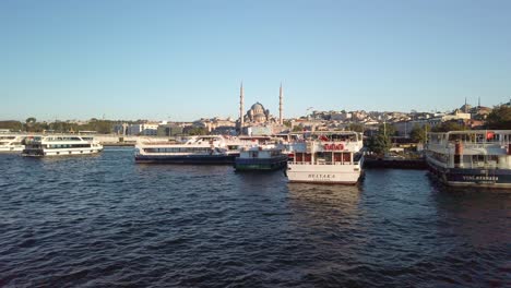 Evening,-from-a-ferry-on-the-Golden-Horn-in-Istanbul,-a-view-of-the-cityscape-of-Eminonu-unfolds