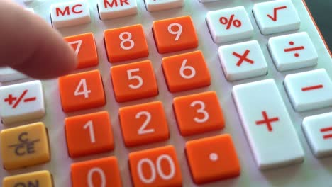 Man's-Fingers-Pressing-Buttons-on-an-Orange-and-White-Calculator-Adding-Numbers,-Close-Up-Shot