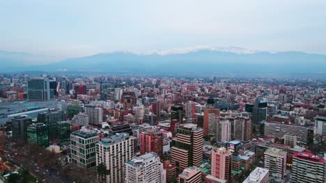 Drone-establishing-shot-of-modern-office-and-residential-buildings-in-Providencia-Santiago-Chile-with-mountain-range-with-pollution-in-the-background