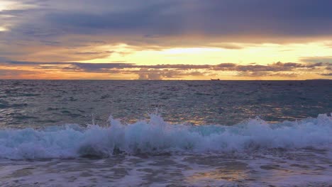 Waves-at-beach-at-sunset,-Slow-Motion