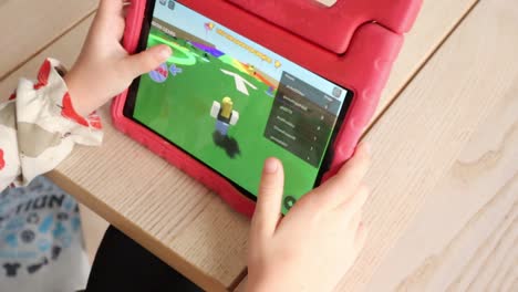 child-plays-roblox-on-her-tablet
