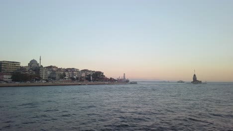 Evening,-cinematic-slow-mo,-the-view-of-uskudar-and-the-adjacent-Maiden's-Tower-from-a-ferry-sailing-along-the-Istanbul-Bosphorus
