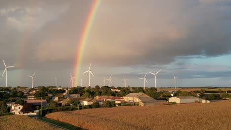 Windkraftanlagen-Drehen-Sich-Vor-Einem-Stürmischen-Himmel-Mit-Einem-Regenbogen