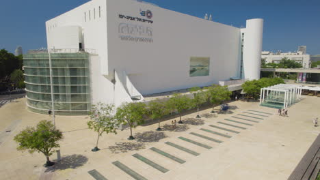 Nuevo-Edificio-Del-Teatro-Habima-En-Tel-Aviv-Desde-La-Estatua-De-Menashe-Kadishman,-Es-Un-Lugar-De-Encuentro-Social-Y-De-Citas:-El-Lugar-Atrae-Visitantes-Por-La-Noche-Debido-A-La-Falta-De-Sombra.
