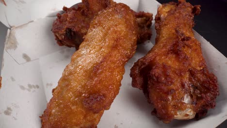 fried-chicken-win-close-up-view,-crispy-brown-fried-food,-slow-anti-clockwise-rotation-in-4k,-served-in-cardboard-takeaway-box