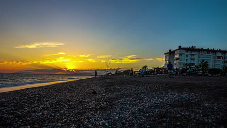 Zeitraffer-Des-Sonnenuntergangs-über-Dem-Strand-Von-Playa-De-Torrox-Mit-Touristen-Im-Hintergrund,-Spanien