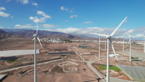 Luftaufnahme-über-Einem-Feld-Von-Windkraftanlagen-In-Einer-Wüstenlandschaft-Auf-Der-Insel-Gran-Canaria-An-Einem-Sonnigen-Tag