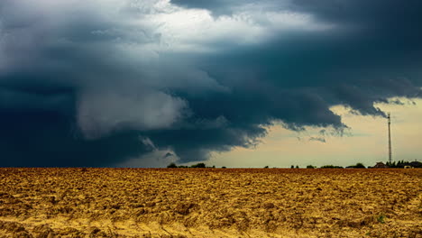 Timelapse-shot-of-dark-rain-clouds-moving-over-soil-in-a-farmland-on-a-cloudy-day