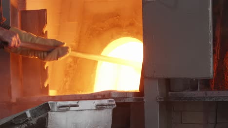 Loading-molten-glass-with-a-shovel-into-a-hot-glass-furnace
