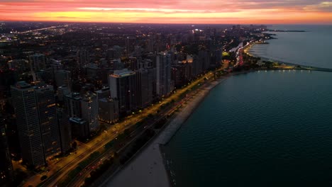 Cars-Driving-Through-US-Highway-41-Along-The-Oak-Street,-And-Concrete-Beach-Near-The-North-Avenue-Beach-Pier-At-Dusk-in-Chicago,-Illinois