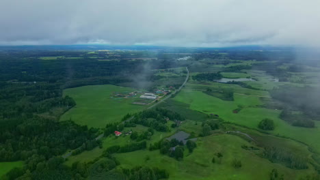 Roadway-Through-Lush-Green-Fields-In-Rural-Area-Seen-Through-Clouds