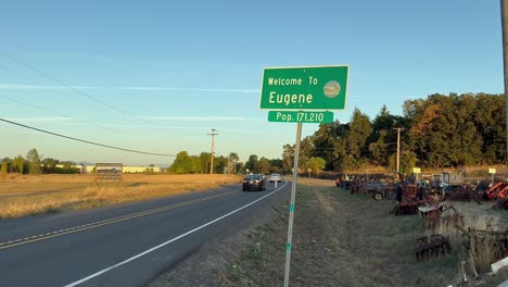 Las-Carreteras-Pasan-El-Cartel-De-Bienvenida-A-Eugene,-Oregon-Y-Extra-Parts