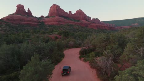 SUV-Compacto-Todoterreno-Conduciendo-Por-Un-Camino-De-Tierra-Hacia-Las-Formaciones-De-Arenisca-En-Sedona,-Arizona