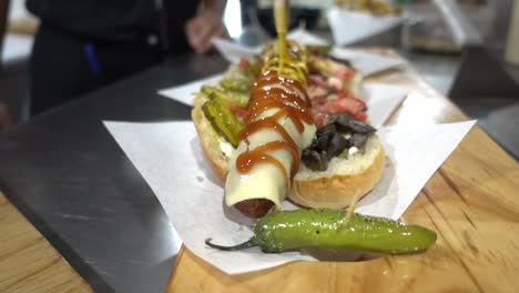 Slow-motion-shot-of-a-hot-dog-being-covered-with-sauces-and-mustard