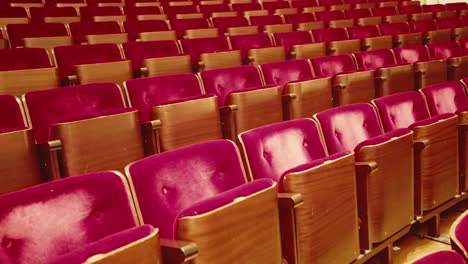 Row-of-vintage-red-velvet-theatre-audience-seats-in-empty-concert-hall
