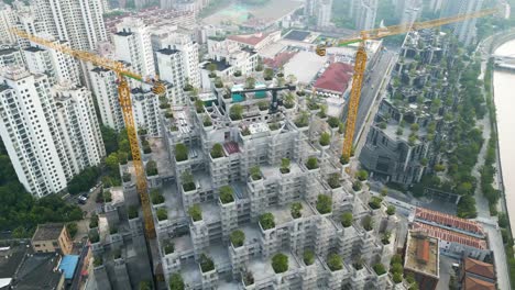 Drone-shot-flying-over-futuristic-1000-Trees-shopping-centre-in-construction-with-surrounding-buildings-and-canal-,-Suzhou-Creek-in-Shanghai-China