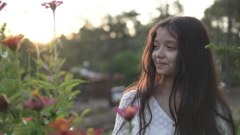 Kleines-Mädchen-In-Einem-Blumenfeld-Trägt-Weißes-Kleid-Und-Lächelt-Während-Des-Sonnenuntergangs