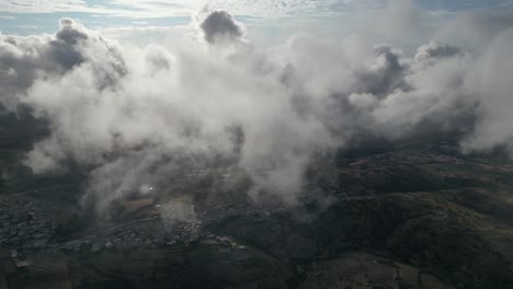 Spektakuläre-Luftaufnahme-Zwischen-Weißen-Wolken-über-Charmanten,-Friedlichen-Kleinstädten