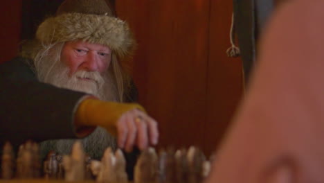 Static-slow-motion-bearded-old-nordic-man-playing-chess-like-boardgame