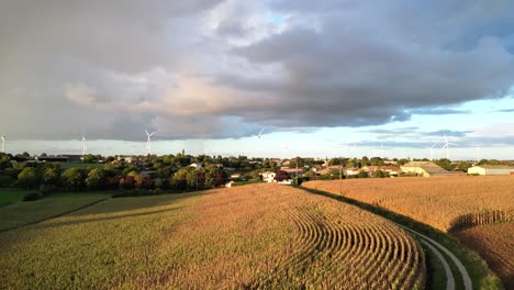 Storm-cloud-with-rain-over-french-village-with-wind-turbines-in-background