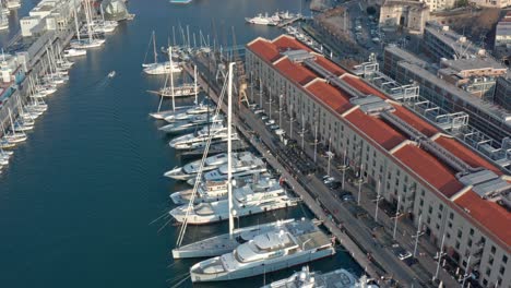Aerial-tilt-up-view-of-luxury-yachts-and-sailboats-docked-at-port-of-Genova