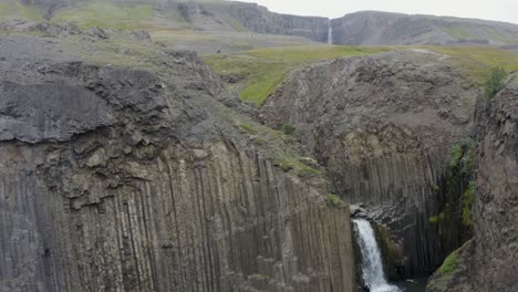 Toma-Aérea-Ascendente-De-La-Cascada-De-Litlanesfoss-Que-Fluye-En-Las-Tierras-Altas-De-Islandia