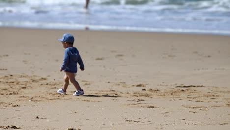 Boy-walks-on-Caparica-beach-sand-and-tries-to-kick-the-ball