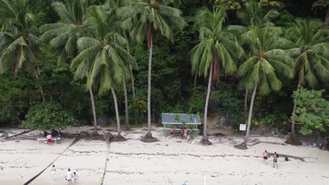 People-of-Island-hopping-tour-boats-having-lunch-on-Pasandigan-Cove-on-Cadlao-Island---El-Nido--Philippines