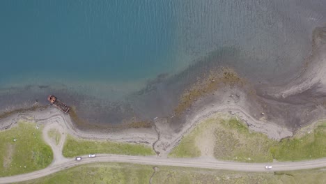 Luftaufnahme-Von-Oben-Nach-Unten-Auf-Den-Mjoifjordur-Fjord-Und-Das-Fahren-Von-Autos-Auf-Der-Küstenstraße-An-Einem-Sonnigen-Tag-In-Island