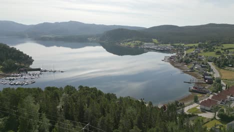 Escena-De-Naturaleza-épica-Del-Tranquilo-Lago-Noruego-Rodeado-De-Un-Frondoso-Bosque,-Aéreo