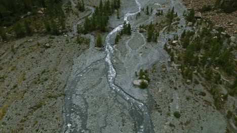 Spectacular-aerial-view-of-mountain-river-in-Alpe-Ventina,-Italy,-tilt-up-reveal