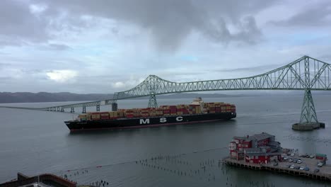 The-MSC-cargo-ship-going-underneath-the-Astoria-Megler-Bridge-in-Astoria,-Oregon-USA