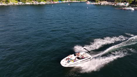 people-on-a-luxurious-speed-boat-sunny-bright-day-on-lake-arrowhead-california-AERIAL-TRUCKING-PAN