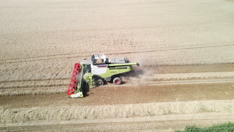 Aerial-static-footage-of-a-combine-harvester-harvesting-a-wheat-crop