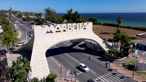 aerial-view-moving-towards-Marbella-sign,-also-knowen-as-the-marbella-arch,-marbella-malaga-vacation-footage