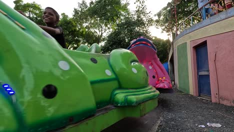 Family-members-with-their-children-riding-the-thumping-frog-ride-in-an-amusement-park-on-holiday