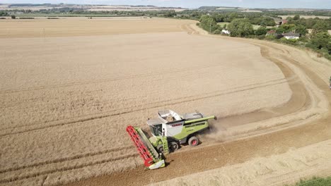 Aerial-footage-of-a-combine-harvester-and-tractor-harvesting-a-wheat-crop-in-field