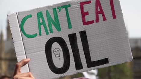 A-handmade-placard-is-held-up-that-reads-“Can’t-Eat-Oil”-on-an-Extinction-Rebellion-protest-calling-for-an-end-to-fossil-fuel-dependency