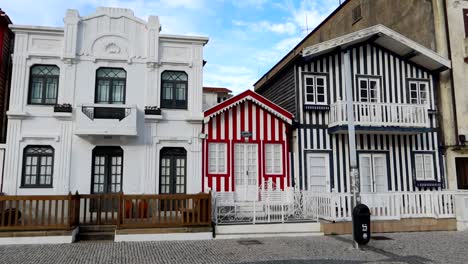 Costa-Nova-establishing-panning-shot-of-colorful-striped-houses,-Portugal,-day
