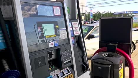 Off-center-angled-fuel-pump-at-Murphy-USA-gas-station-counting-up-with-traffic-passing-by-in-the-background