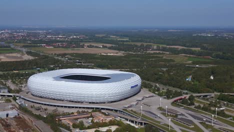 Amazing-aerial-top-view-flight-Bavarian-Munich-Arena-stadium-national-football-soccer-team-Germany,-summer-sunny-blue-sky-day-23